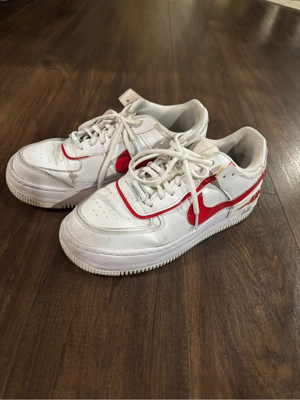 Nike Air Force 1 white sneakers with red Nike swoosh
